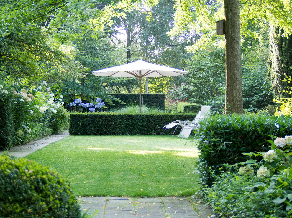 Пример оригинального дизайна: летний регулярный сад среднего размера на боковом дворе в классическом стиле с растениями в контейнерах, полуденной тенью и мощением тротуарной плиткой