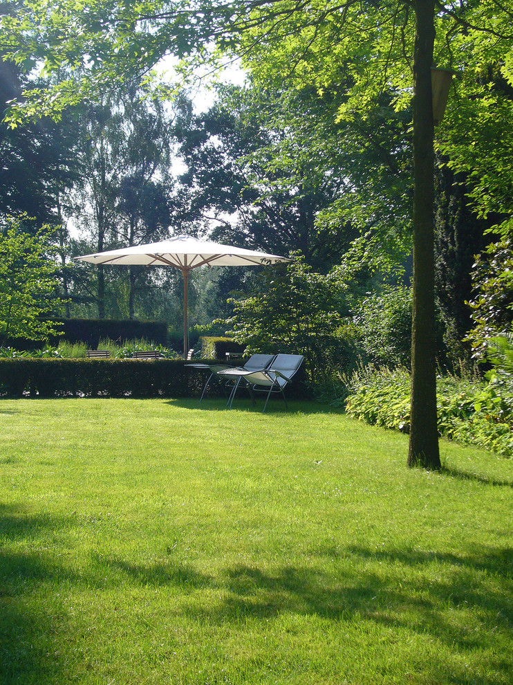 Ejemplo de jardín clásico de tamaño medio en verano en patio lateral con exposición parcial al sol
