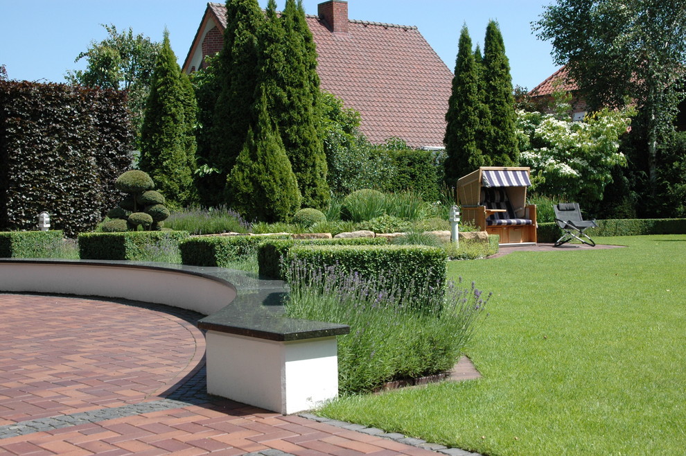 This is an example of a large classic full sun garden in Other with a garden path and brick paving.
