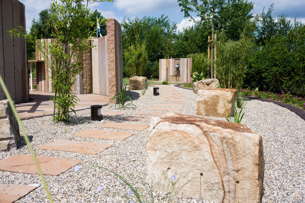 Foto di un grande giardino design esposto in pieno sole dietro casa in estate con un ingresso o sentiero e pavimentazioni in pietra naturale