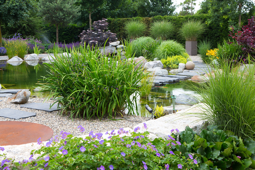На фото: солнечный, весенний регулярный сад среднего размера на заднем дворе в современном стиле с хорошей освещенностью и покрытием из гравия