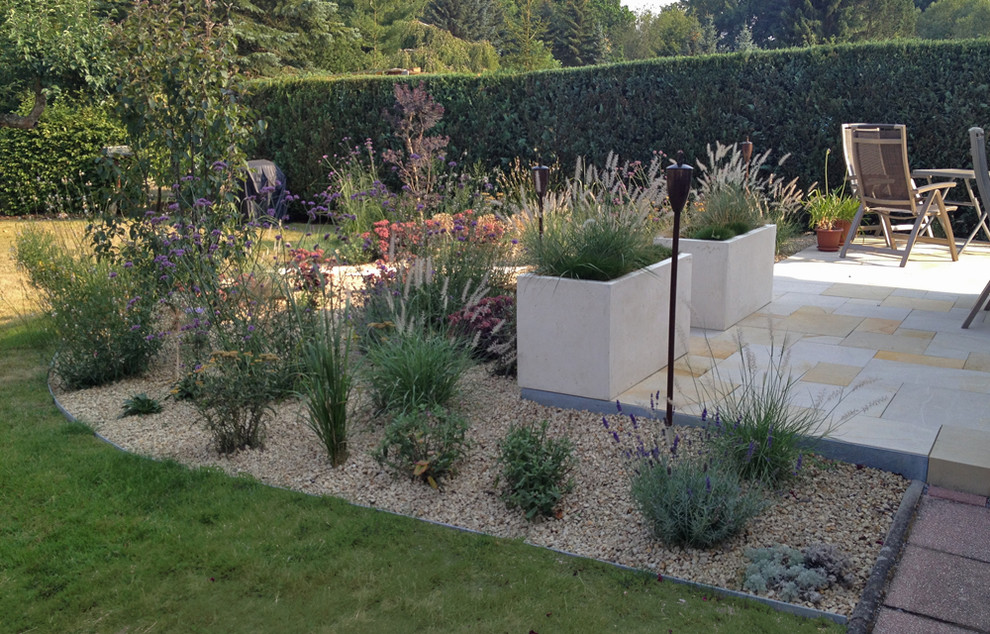 Diseño de jardín contemporáneo pequeño en verano en patio lateral con jardín de macetas, exposición total al sol y adoquines de piedra natural