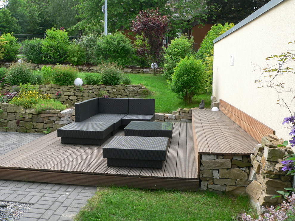 Immagine di un giardino minimal di medie dimensioni con un muro di contenimento, un pendio, una collina o una riva e pedane