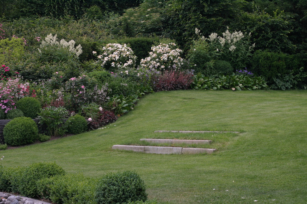 Aménagement d'un grand jardin contemporain l'été avec une exposition ensoleillée et une pente, une colline ou un talus.