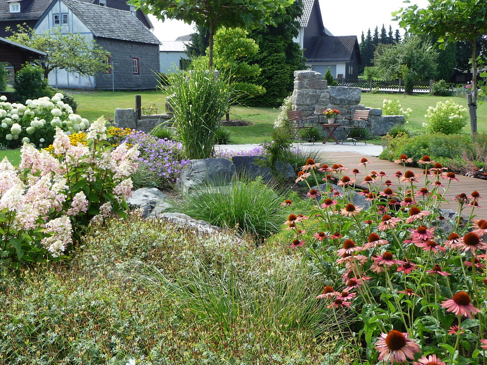 Inspiration för en stor vintage trädgård i full sol i slänt på sommaren, med en trädgårdsgång och trädäck