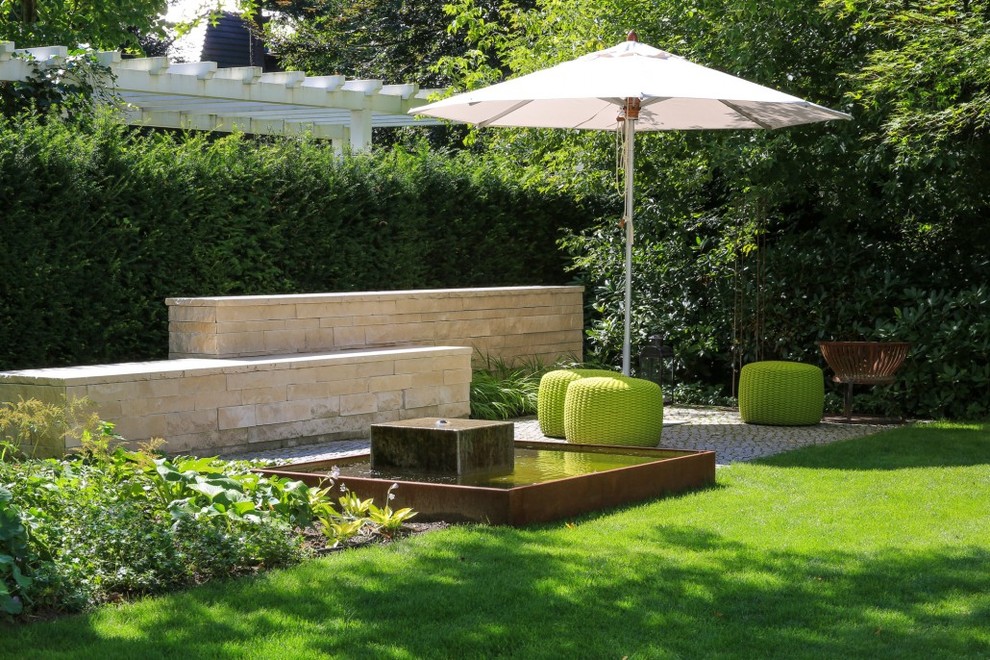 Mittelgroßer, Halbschattiger Moderner Garten im Sommer mit Wasserspiel und Natursteinplatten in Berlin