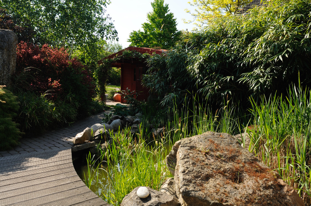Ispirazione per un laghetto da giardino design esposto a mezz'ombra nel cortile laterale in estate con pavimentazioni in pietra naturale