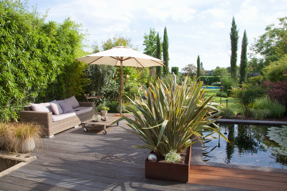 Photo of a large mediterranean partial sun garden for summer in Dusseldorf with a pond and decking.