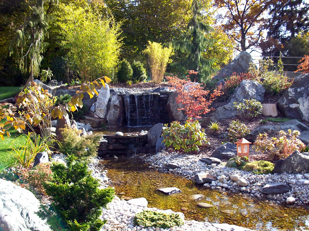 Inspiration för en stor rustik trädgård i delvis sol, med en fontän