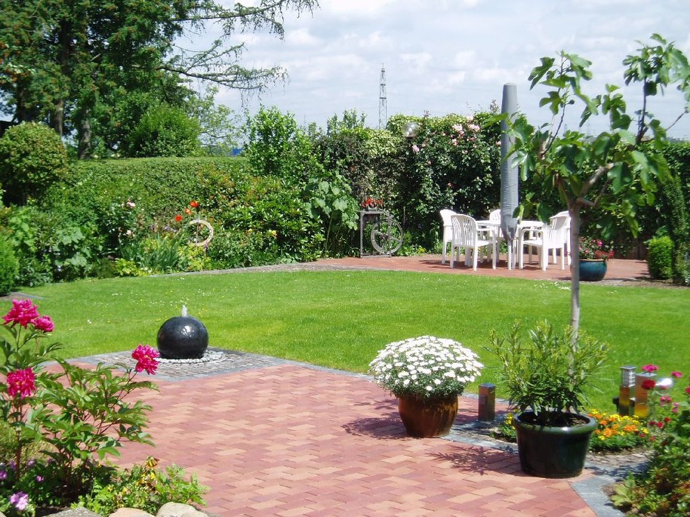 Idee per un giardino minimal esposto in pieno sole di medie dimensioni e dietro casa in estate con fontane e pavimentazioni in mattoni