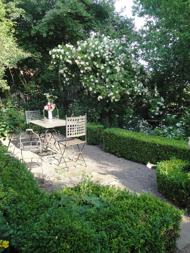 Aménagement d'un petit aménagement d'entrée ou allée de jardin arrière campagne l'été avec une exposition partiellement ombragée et du gravier.