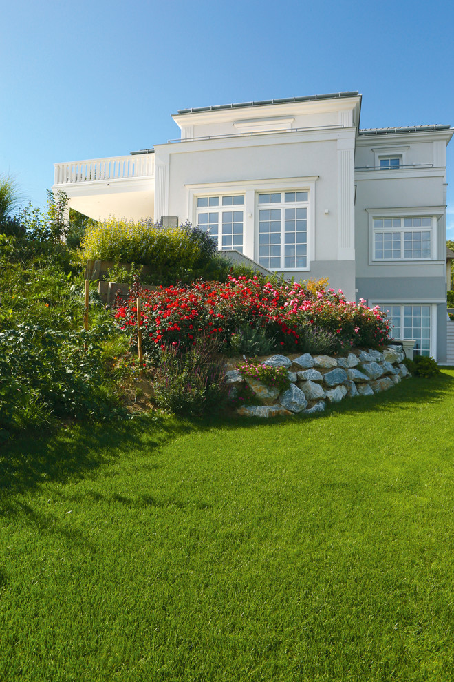 Esempio di un ampio giardino country esposto a mezz'ombra in estate con un pendio, una collina o una riva e pavimentazioni in pietra naturale