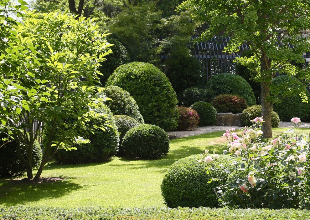 Imagen de jardín tradicional de tamaño medio en verano en patio trasero con exposición parcial al sol y gravilla
