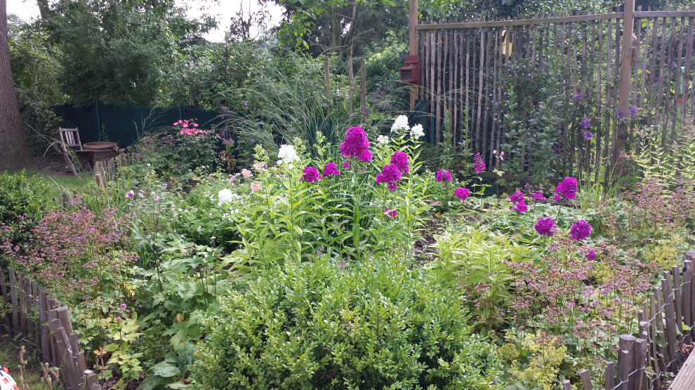 На фото: летний участок и сад среднего размера на боковом дворе в стиле кантри с клумбами и полуденной тенью с
