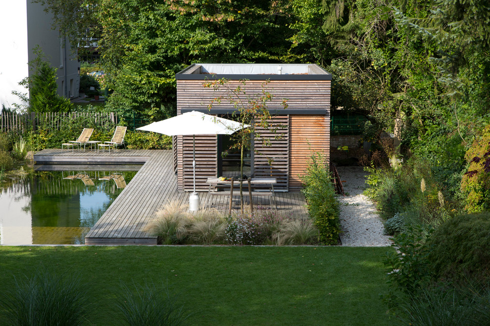Exemple d'un grand jardin arrière tendance avec une exposition partiellement ombragée et une terrasse en bois.