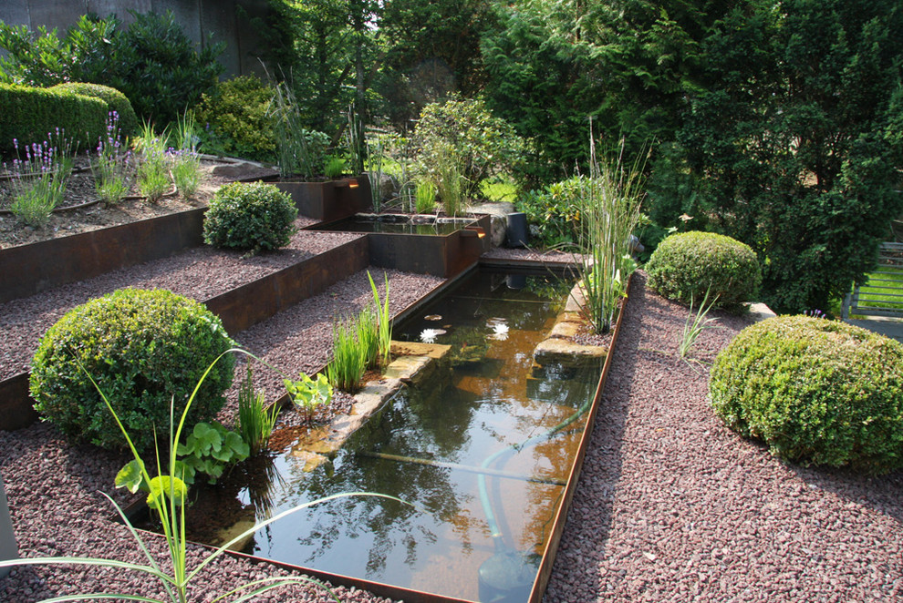 Ispirazione per un grande giardino xeriscape tradizionale esposto in pieno sole in estate con un pendio, una collina o una riva, fontane e ghiaia