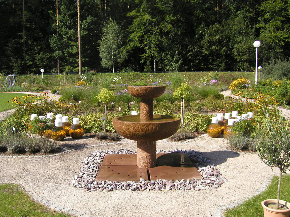 Foto på en stor vintage formell trädgård i full sol, med en fontän
