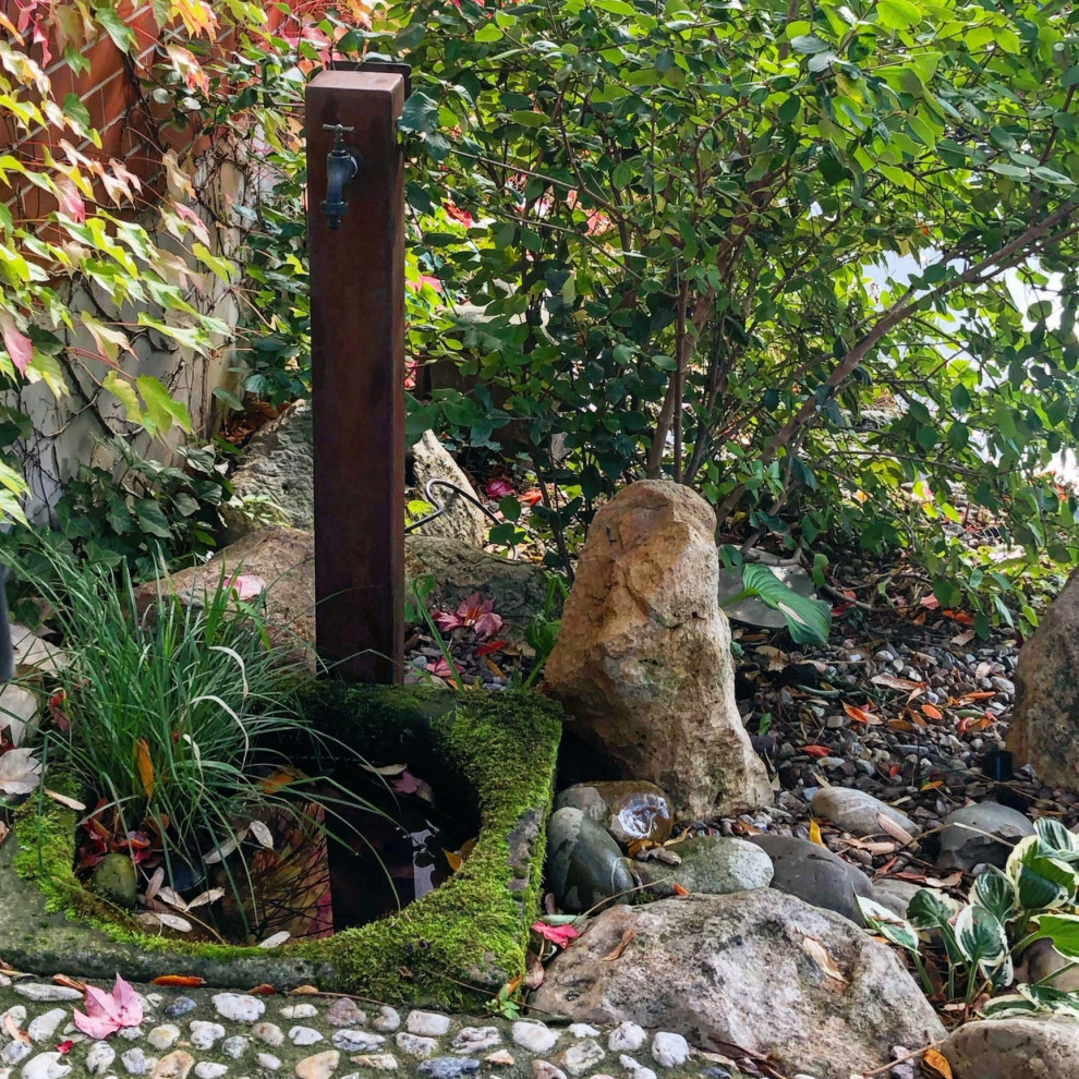 Modelo de jardín grande en otoño en patio trasero con roca decorativa, exposición reducida al sol y gravilla