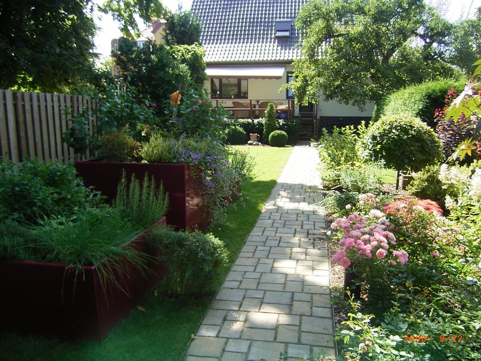 Idée de décoration pour un jardin surélevé latéral de taille moyenne et l'été avec une exposition partiellement ombragée et des pavés en béton.