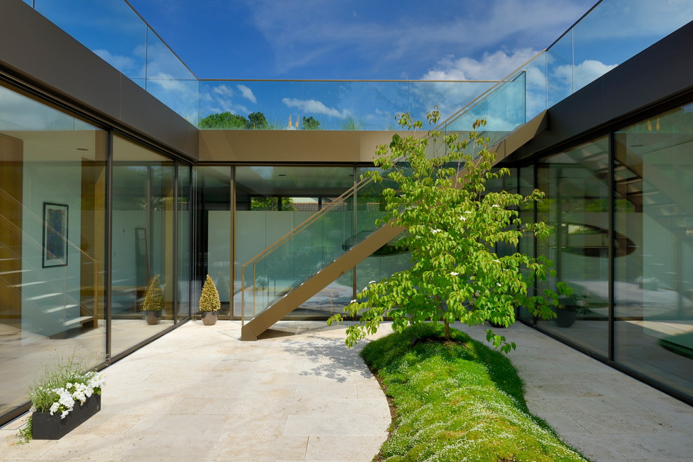 Ejemplo de jardín moderno de tamaño medio en verano en patio con exposición parcial al sol y adoquines de piedra natural
