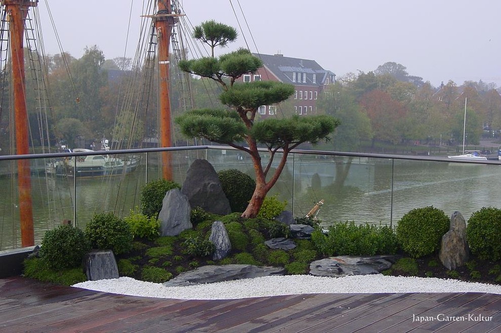 Exemple d'un jardin asiatique de taille moyenne et l'été avec une exposition ensoleillée et des pavés en pierre naturelle.