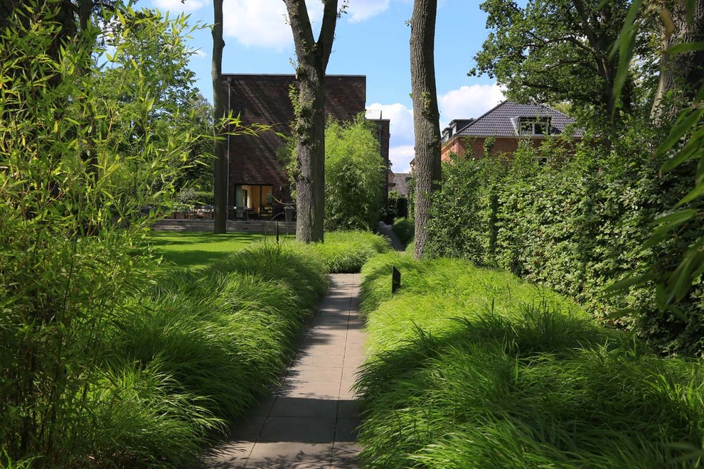 Halbschattiger Moderner Gartenweg mit Natursteinplatten in Hamburg