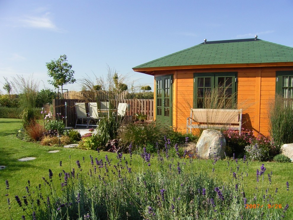 Moderner Garten im Sommer mit direkter Sonneneinstrahlung und Natursteinplatten in Sonstige