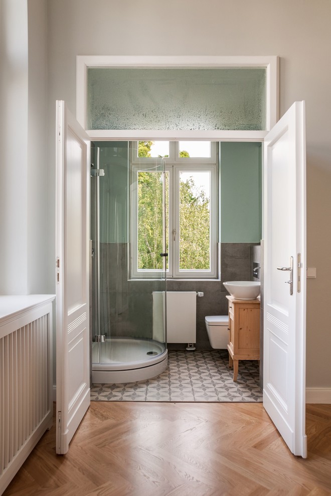 Cette photo montre un WC suspendu nature en bois clair de taille moyenne avec un placard à porte affleurante, un carrelage gris, un carrelage de pierre, un mur bleu, carreaux de ciment au sol, une vasque, un plan de toilette en bois, un sol multicolore et un plan de toilette marron.