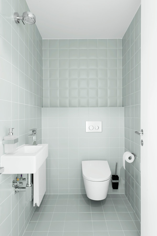 Idee per un piccolo bagno di servizio moderno con WC sospeso, piastrelle in ceramica, pavimento con piastrelle in ceramica, lavabo sospeso, piastrelle grigie, pareti grigie e pavimento grigio