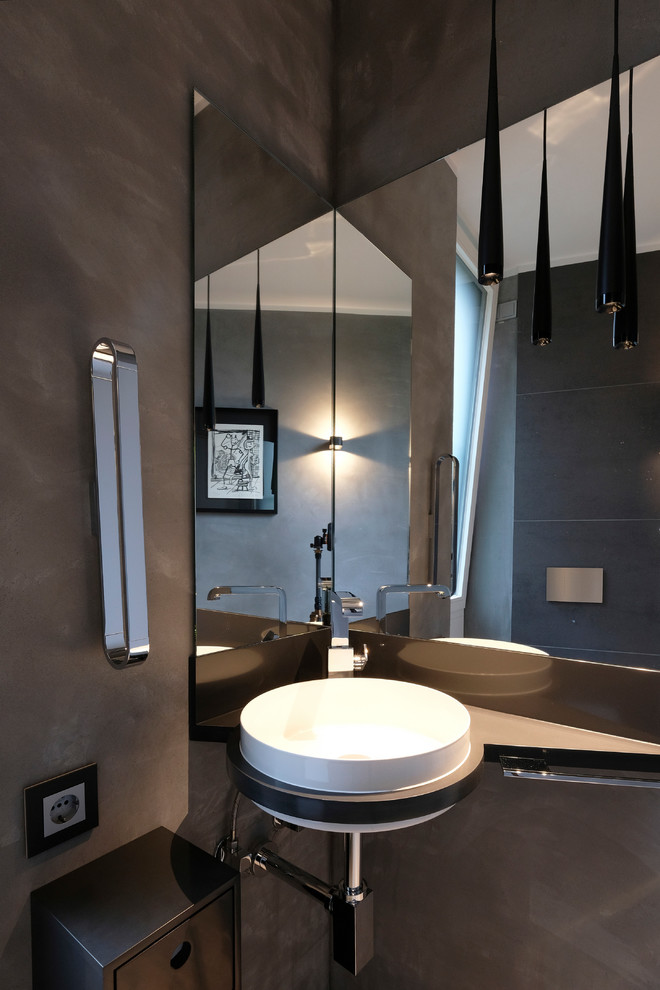 Inspiration for a small contemporary cloakroom in Dortmund with flat-panel cabinets, black cabinets, grey walls, limestone flooring, a built-in sink, black worktops and grey tiles.