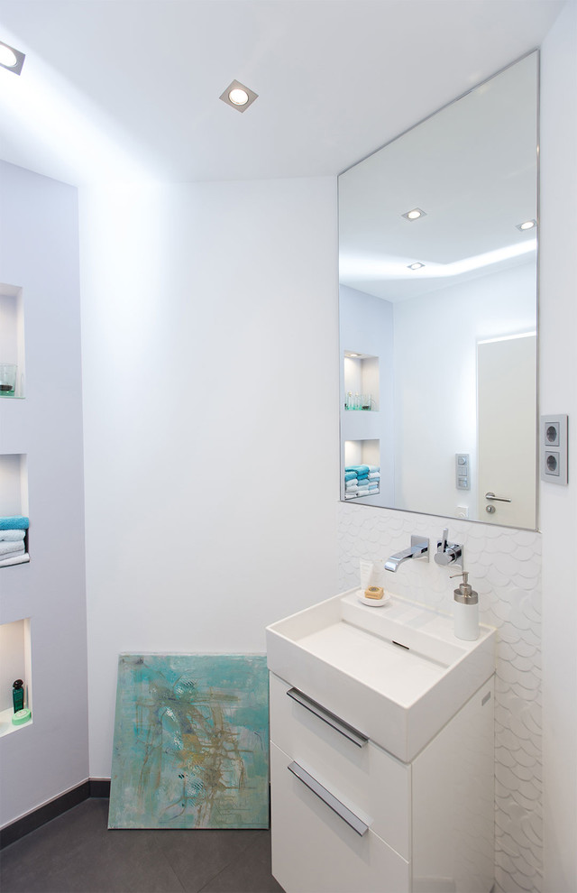 Kleine Moderne Gästetoilette mit flächenbündigen Schrankfronten, weißen Schränken, weißer Wandfarbe, Aufsatzwaschbecken und grauem Boden in Dortmund