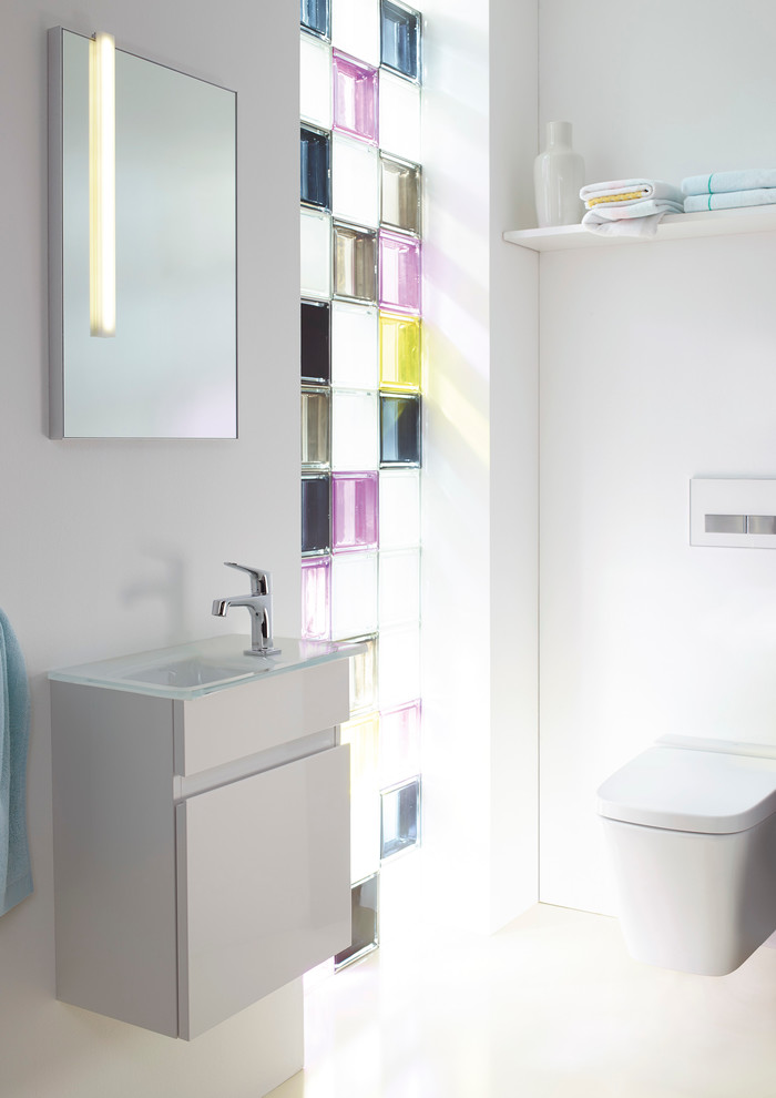 This is an example of a small contemporary cloakroom in Nuremberg with a trough sink, flat-panel cabinets, white cabinets, a wall mounted toilet and white walls.