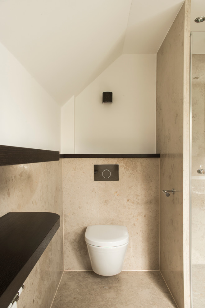 Design ideas for a small contemporary cloakroom in Dusseldorf with limestone flooring and beige floors.