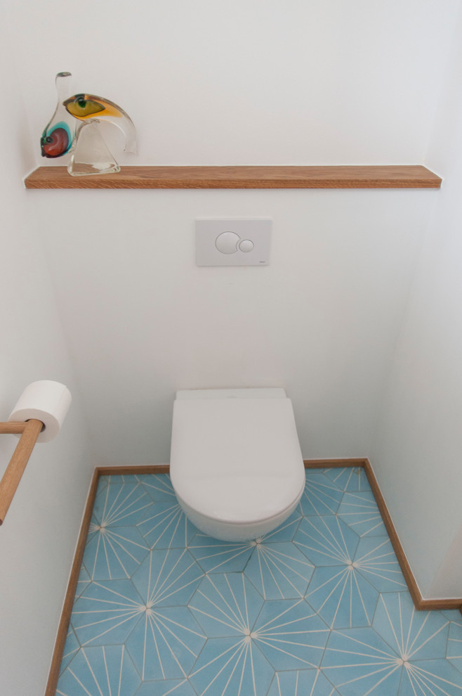 Ejemplo de aseo contemporáneo pequeño con sanitario de dos piezas, paredes blancas, suelo de baldosas de cerámica y suelo azul