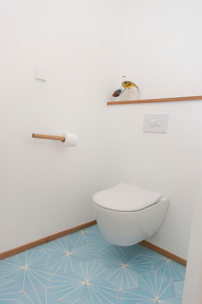 Idée de décoration pour un petit WC et toilettes nordique avec WC séparés, un mur blanc, un sol en carrelage de céramique et un sol bleu.