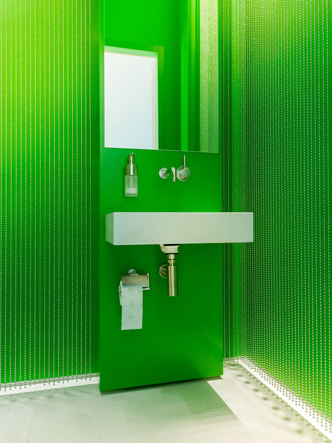 Idee per un bagno di servizio moderno di medie dimensioni con ante verdi, WC a due pezzi, piastrelle bianche, pareti verdi, lavabo sospeso e pavimento beige