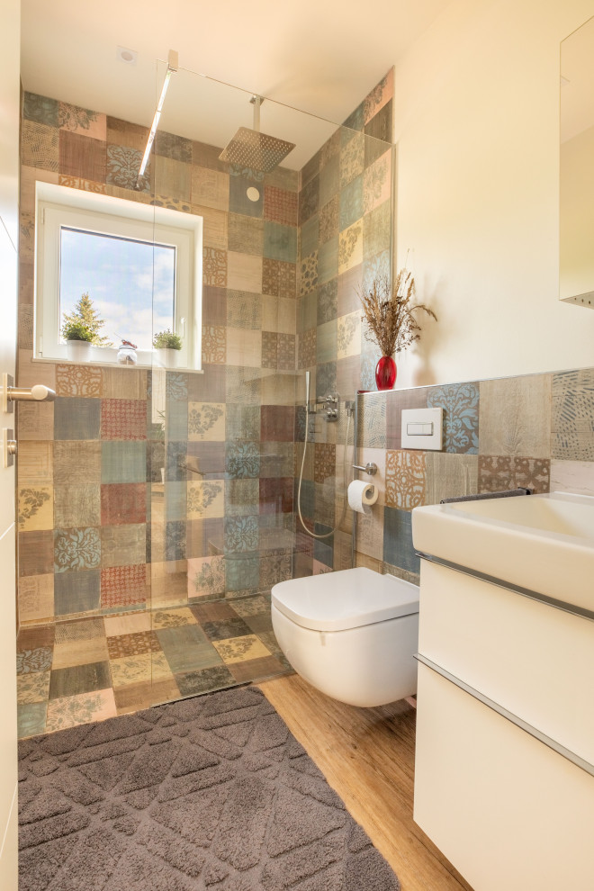 На фото: маленькая ванная комната в современном стиле с белыми фасадами, инсталляцией, разноцветной плиткой, разноцветными стенами, полом из винила, подвесной раковиной, коричневым полом и встроенной тумбой для на участке и в саду с