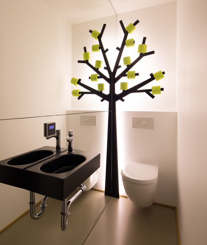 Inspiration för ett litet funkis toalett, med en vägghängd toalettstol, vita väggar och ett väggmonterat handfat