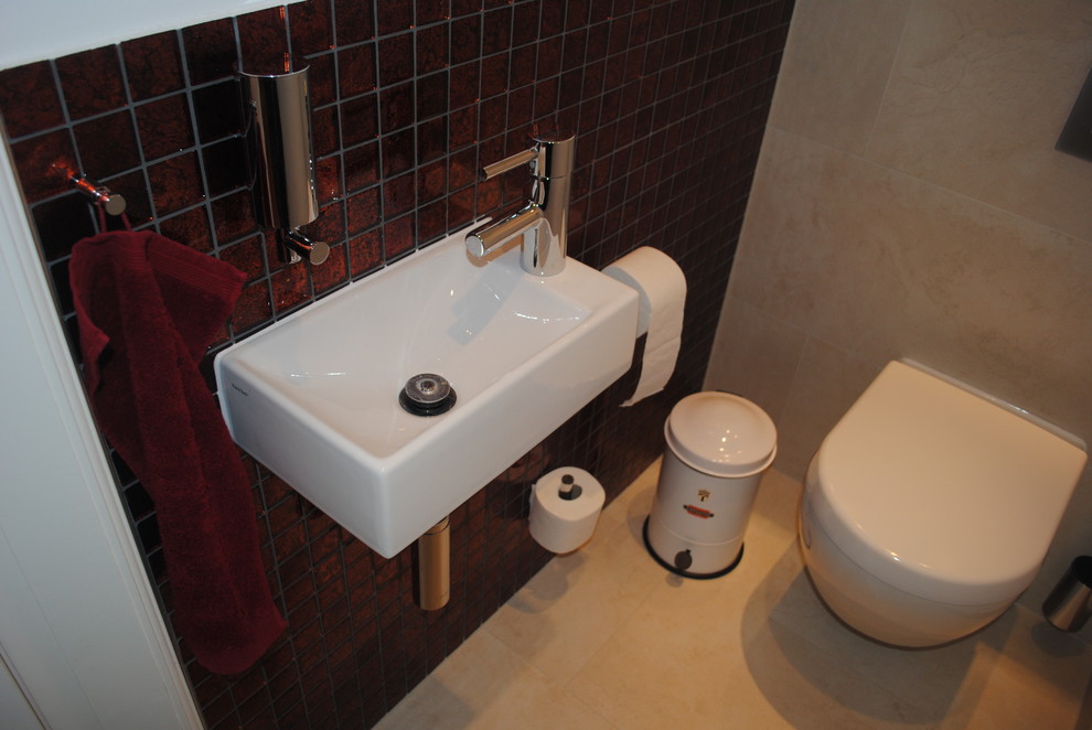 На фото: туалет в современном стиле с инсталляцией, красной плиткой, плиткой мозаикой, белыми стенами, полом из керамической плитки, подвесной раковиной и бежевым полом