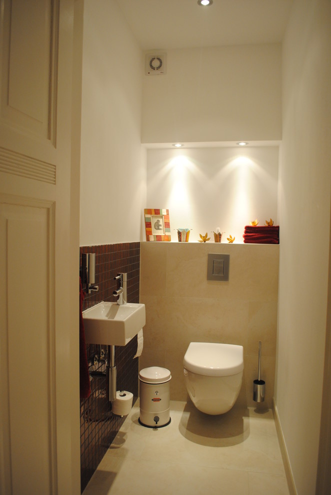 Bild på ett funkis toalett, med en vägghängd toalettstol, röd kakel, mosaik, vita väggar, klinkergolv i keramik, ett väggmonterat handfat och beiget golv