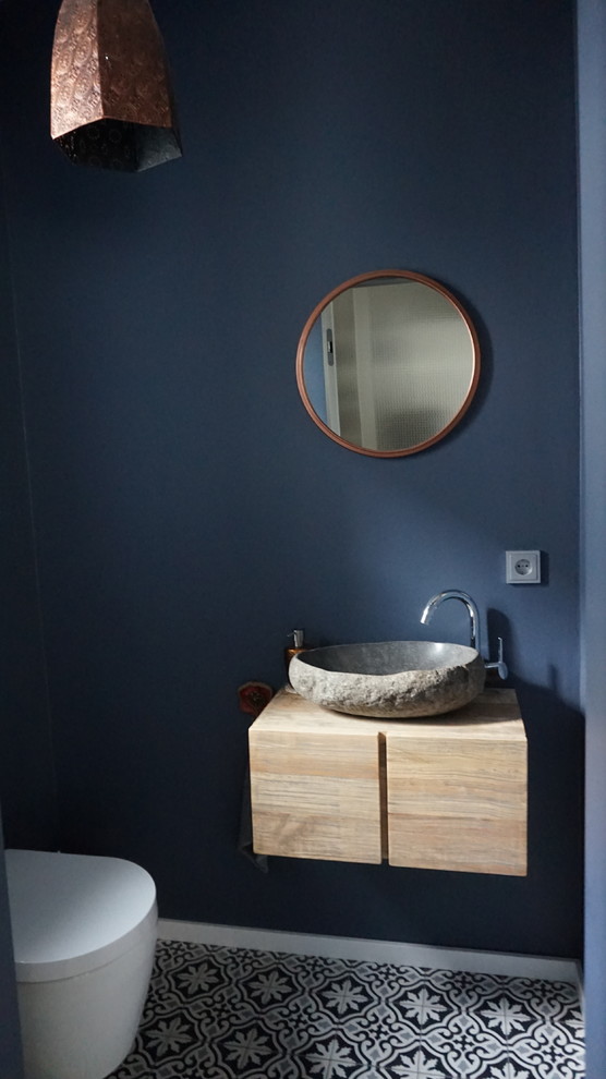 Пример оригинального дизайна: маленький туалет в современном стиле с плоскими фасадами, светлыми деревянными фасадами, черно-белой плиткой, цементной плиткой, синими стенами, полом из мозаичной плитки, настольной раковиной, столешницей из талькохлорита и разноцветным полом для на участке и в саду