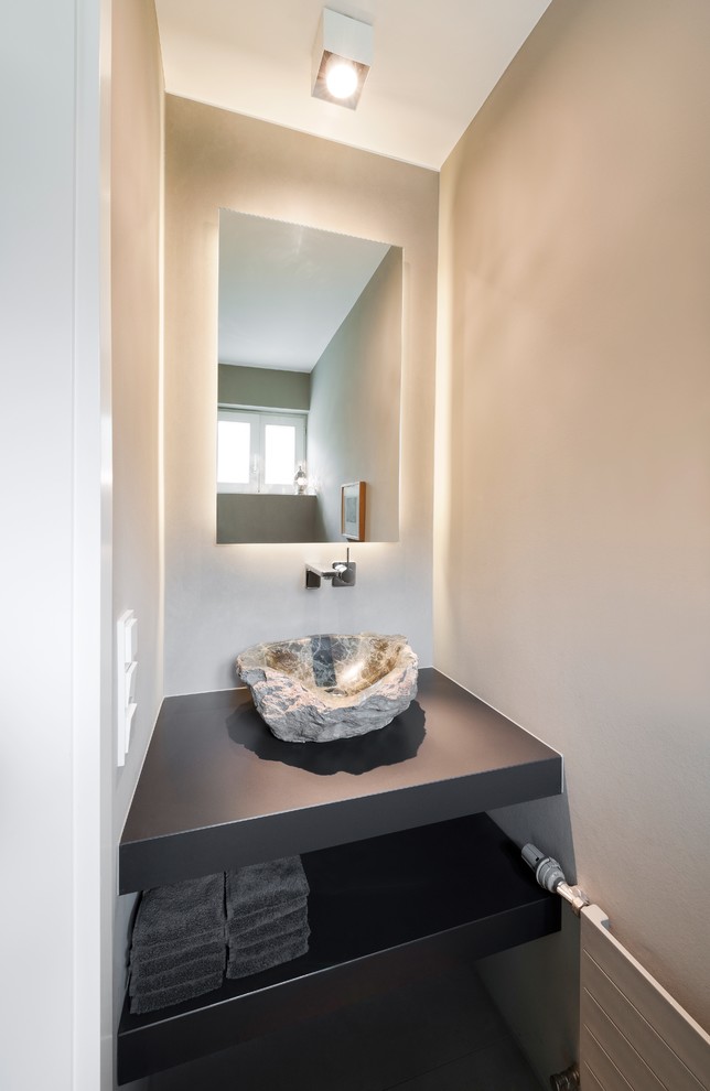 Diseño de aseo actual pequeño con armarios abiertos, lavabo sobreencimera y paredes beige