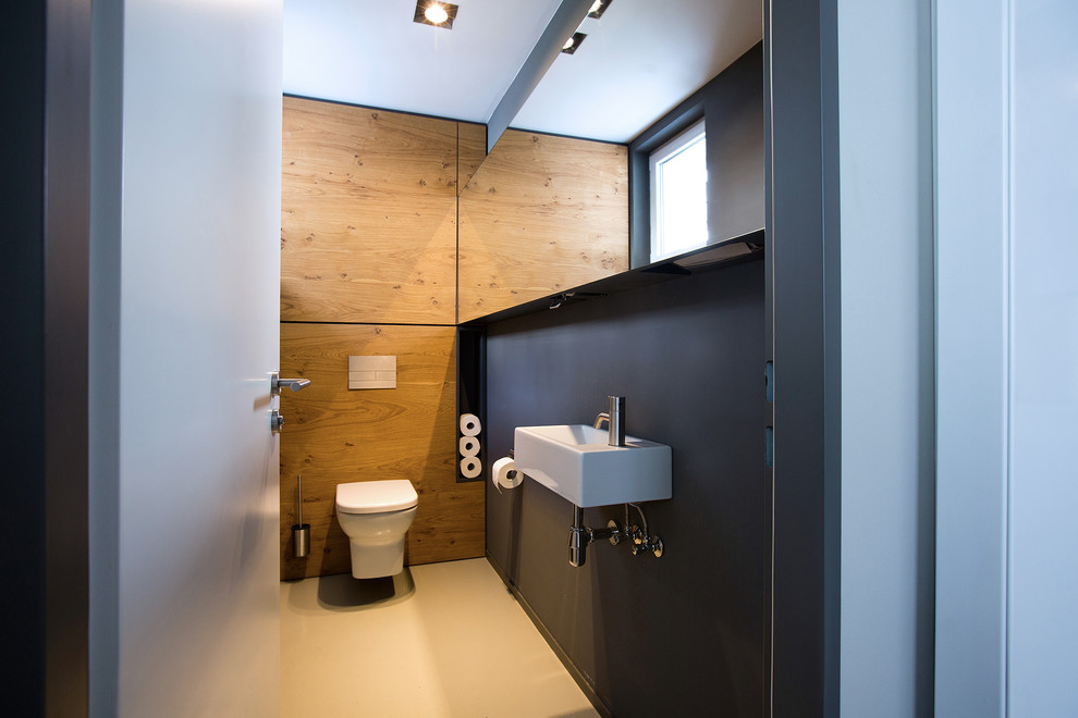 Kleine Moderne Gästetoilette mit flächenbündigen Schrankfronten, hellen Holzschränken, grauer Wandfarbe, Betonboden und Aufsatzwaschbecken in Frankfurt am Main