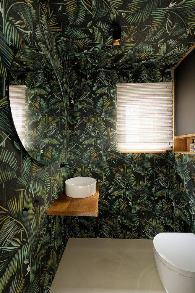 Cette image montre un WC suspendu design avec un mur multicolore, une vasque, un plan de toilette en bois, un sol beige et un plan de toilette beige.