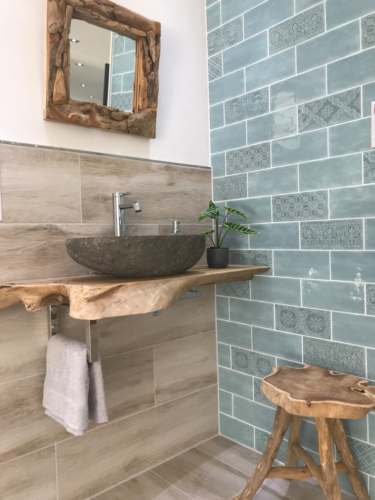 Kleine Shabby-Style Gästetoilette mit Metrofliesen, Keramikboden, Aufsatzwaschbecken, Waschtisch aus Holz, braunem Boden und brauner Waschtischplatte in Dortmund
