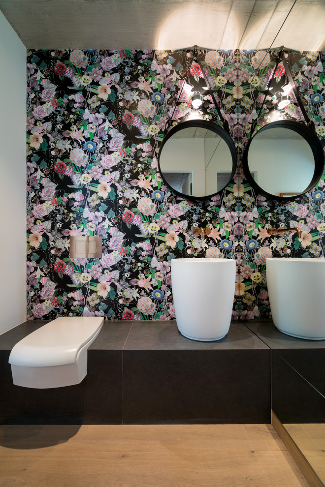 Immagine di un piccolo bagno di servizio contemporaneo con WC a due pezzi, pareti multicolore, pavimento in legno massello medio, lavabo a colonna, pavimento marrone e top marrone