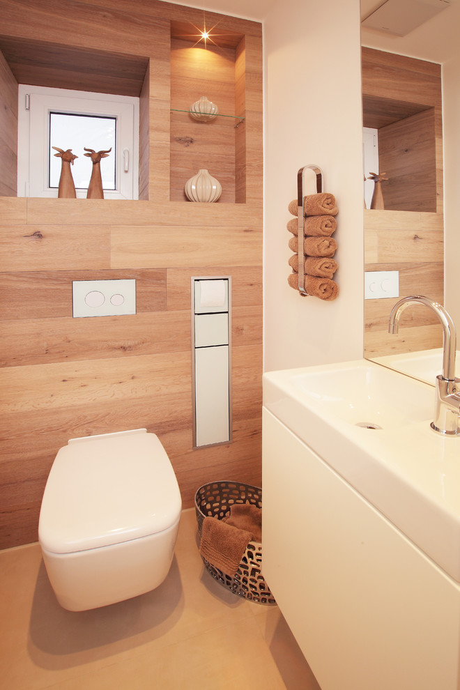Exemple d'un petit WC suspendu tendance avec un placard à porte plane, des portes de placard blanches, un mur beige, un sol en carrelage de céramique, une vasque et un sol beige.