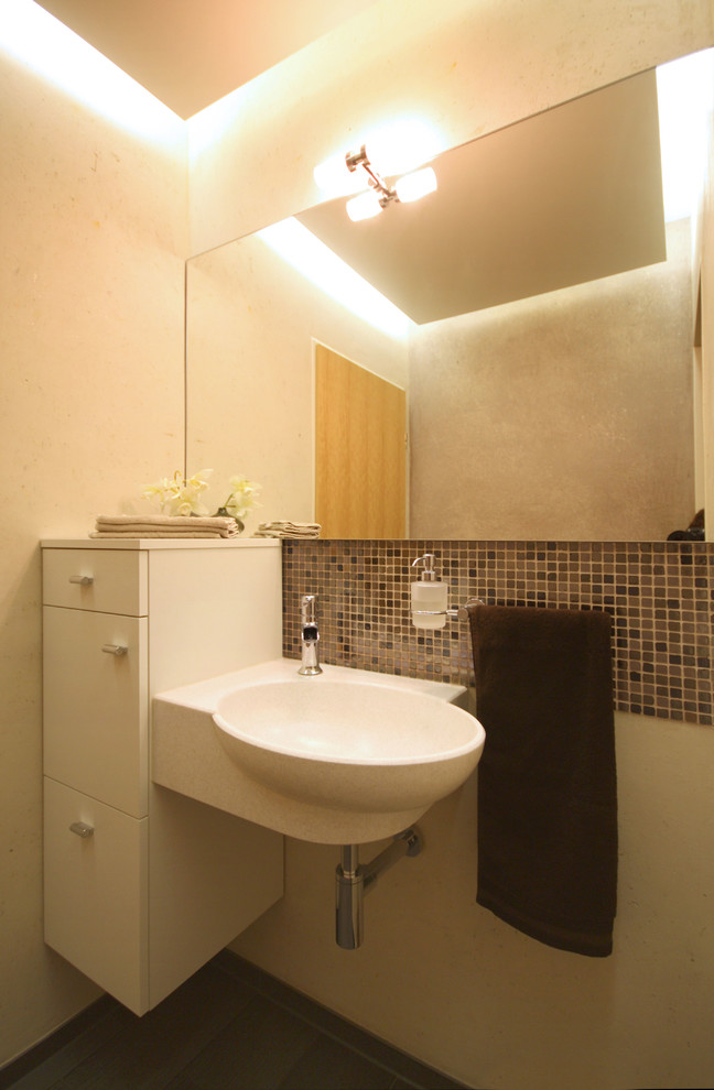 Inspiration pour un petit WC et toilettes design avec une grande vasque, un carrelage marron, mosaïque, un mur beige et un sol en carrelage de porcelaine.