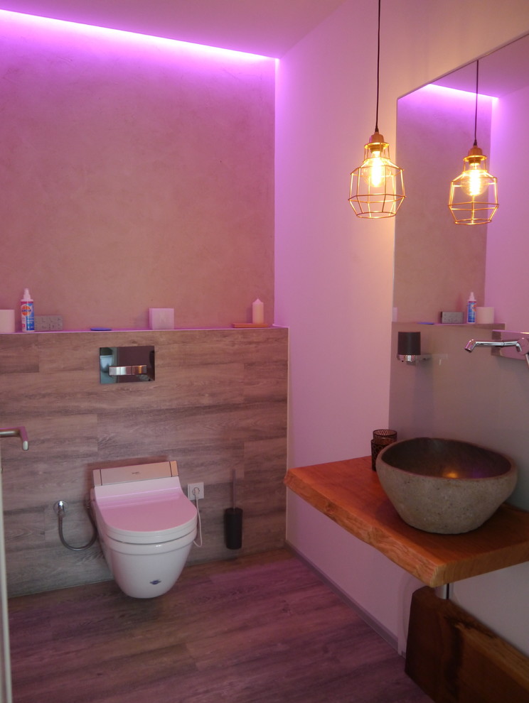 Mittelgroße Moderne Gästetoilette mit Aufsatzwaschbecken, Wandtoilette, beiger Wandfarbe und Vinylboden in Sonstige