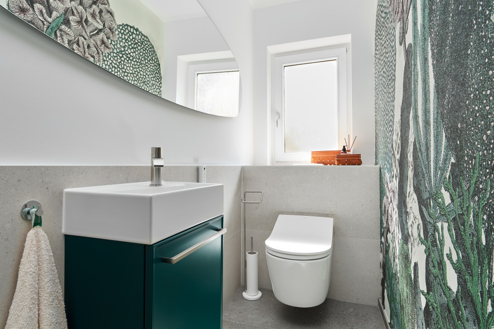 Kleine Moderne Gästetoilette mit flächenbündigen Schrankfronten, grünen Schränken, Wandtoilette, grauen Fliesen, weißer Wandfarbe und grauem Boden in Stuttgart